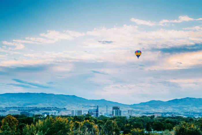 Un globo aerostático flotando sobre un paisaje urbano.