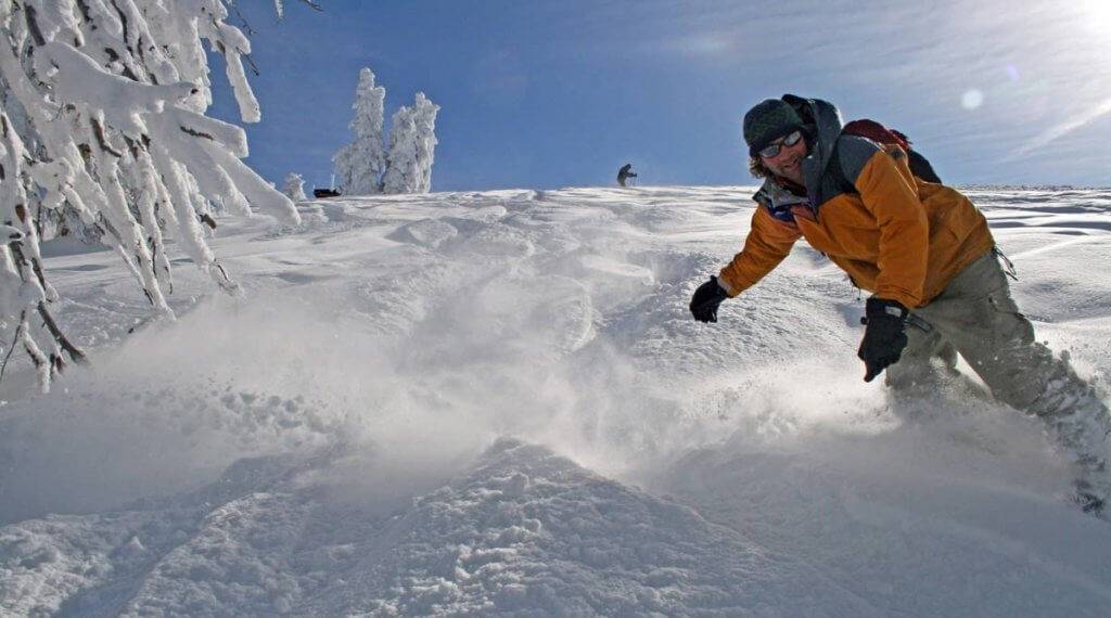 A snowboarder riding down a mountain of snow.