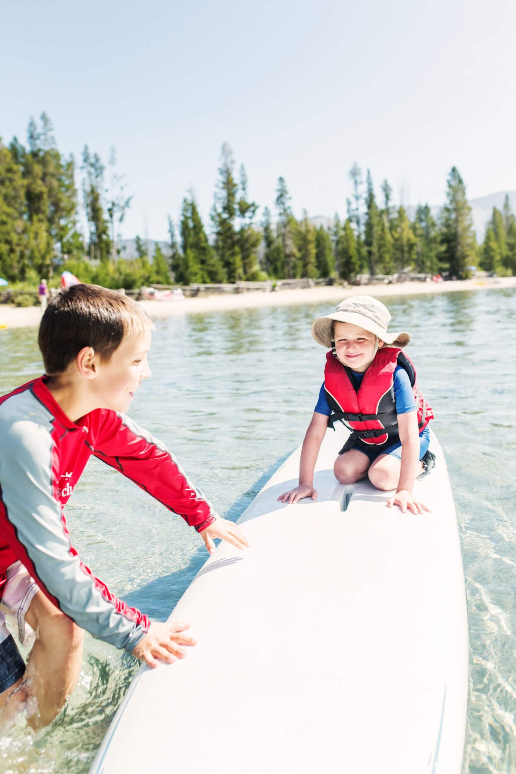 A child learning to SUP on a lake.