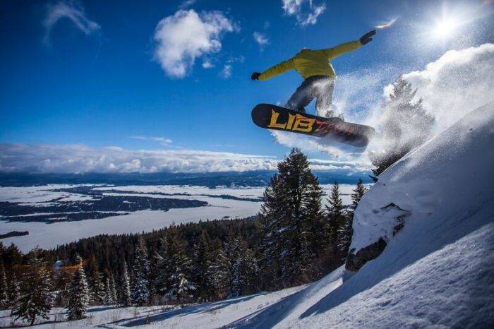 A snowboarder headed down a ski run.