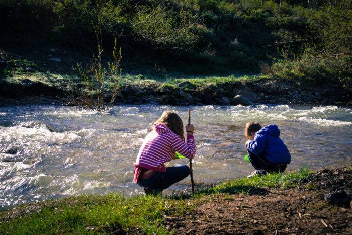 kids panning for gold in a creek