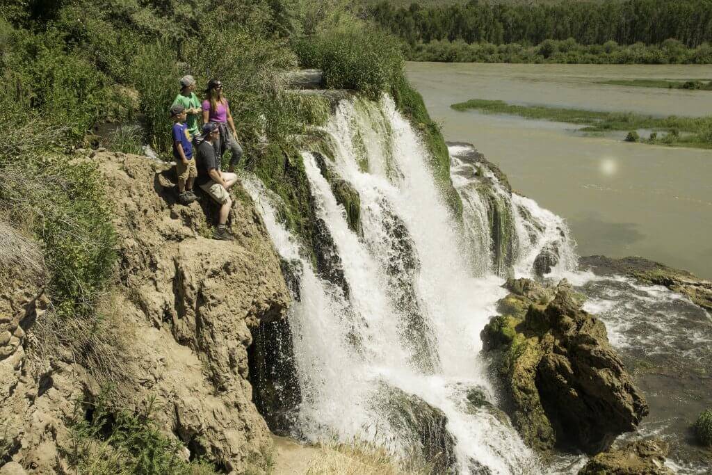 family standing at the top of waterfall