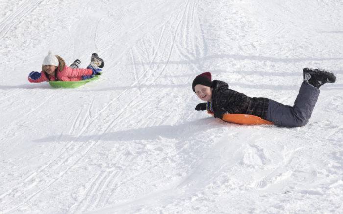 kids on a snow tubing hill