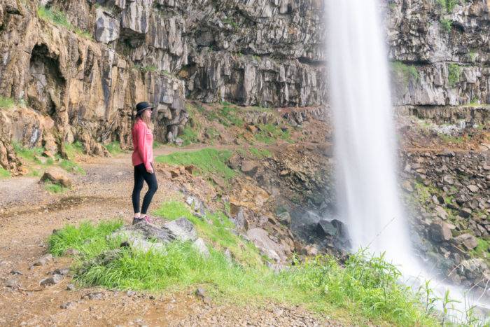 woman standing by waterfall
