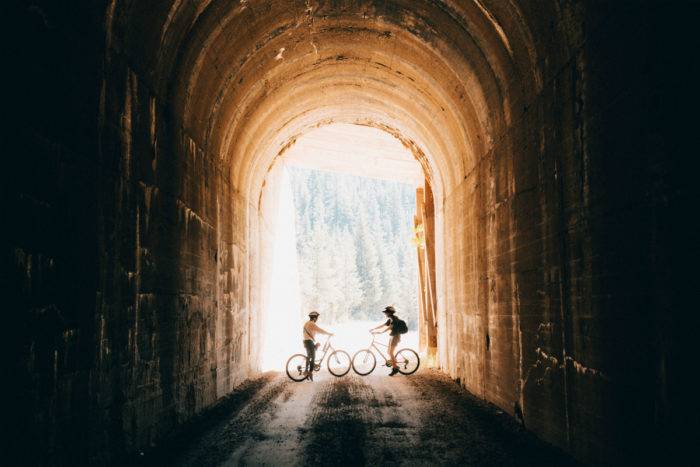 two bike riders in a tunnel
