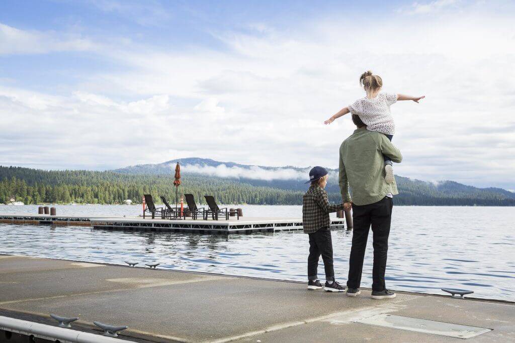 outdoor places to visit near me A father holding his child on the dock on Payette Lake.