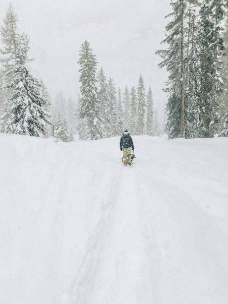 man pulling sled in the snow