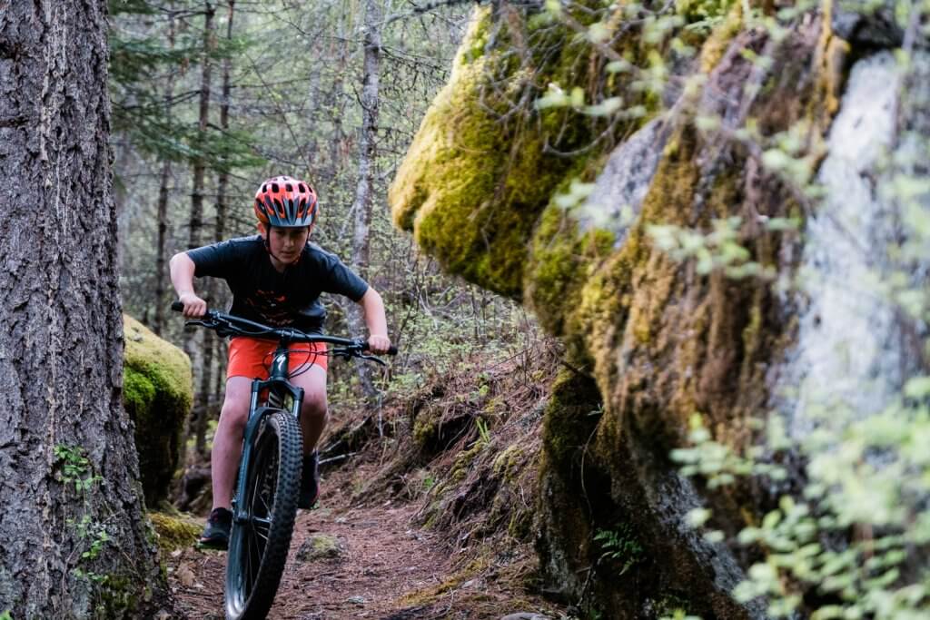 boy riding a mountain bike on forest trail