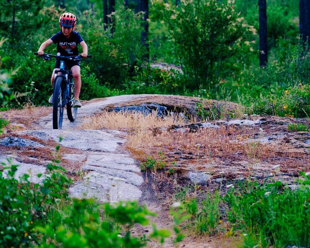 boy mountain bike riding on rock slab