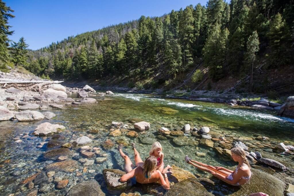 people sitting in riverside hot spring
