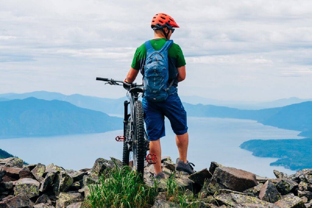 mountain bike rider on rocky point overlooking lake