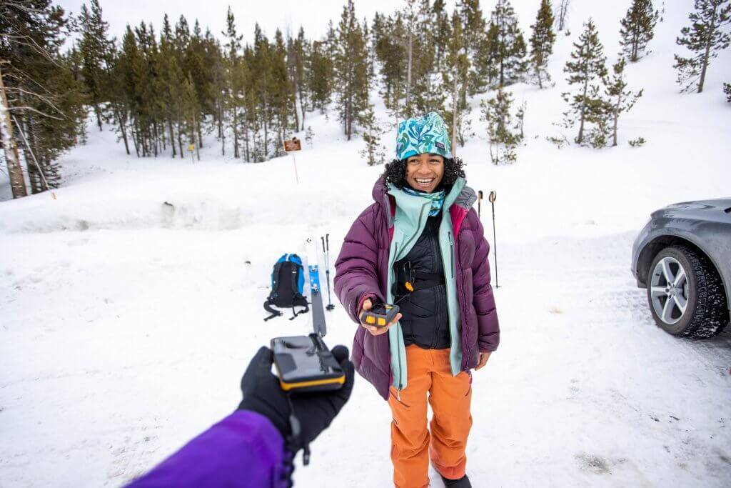 woman checking avalanche beacon