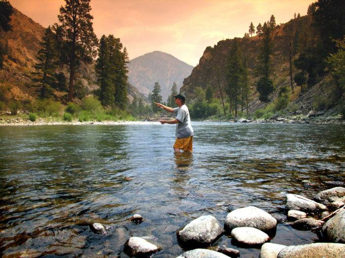 A man fishing in a river.