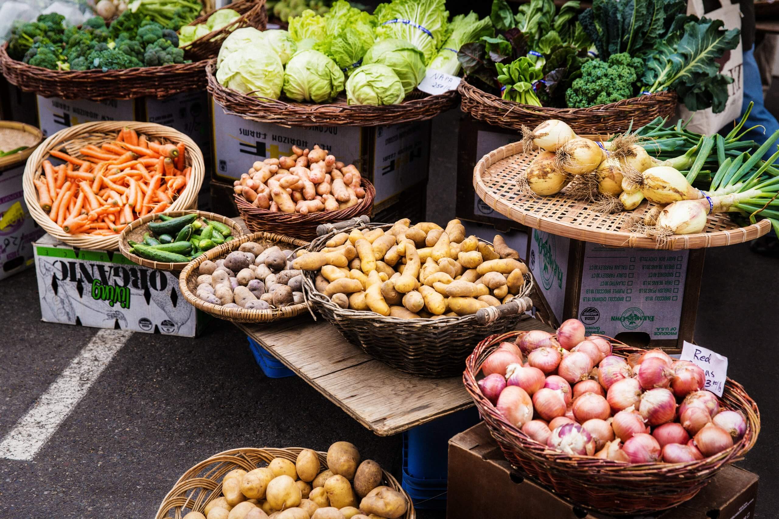 Fresh produce in baskets at a farmers market.