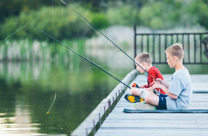 Two kids fishing on a dock.