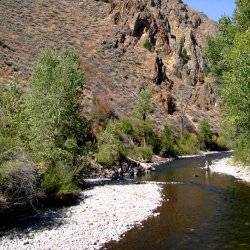 A person in the far distance wades through a shallow portion of the Big Wood River.