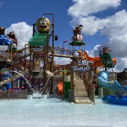 A water feature play area with waterslides and a giant potato-shaped tipping water bucket.