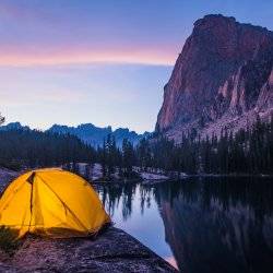 A lit tent beneath Elephant's Perch at night.