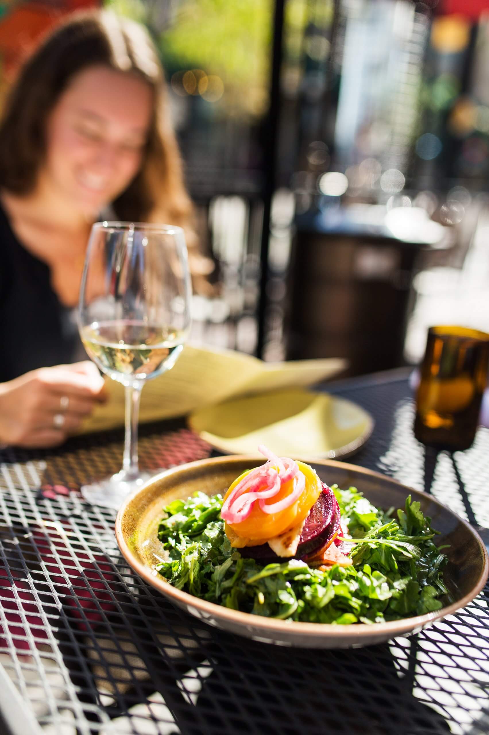 A bowl of salad with white wine on a warm summer day.