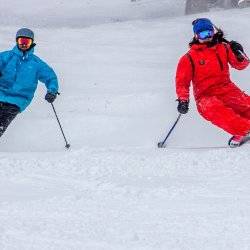 A couple in snow gear skiing at Pebble Creek Ski Area.