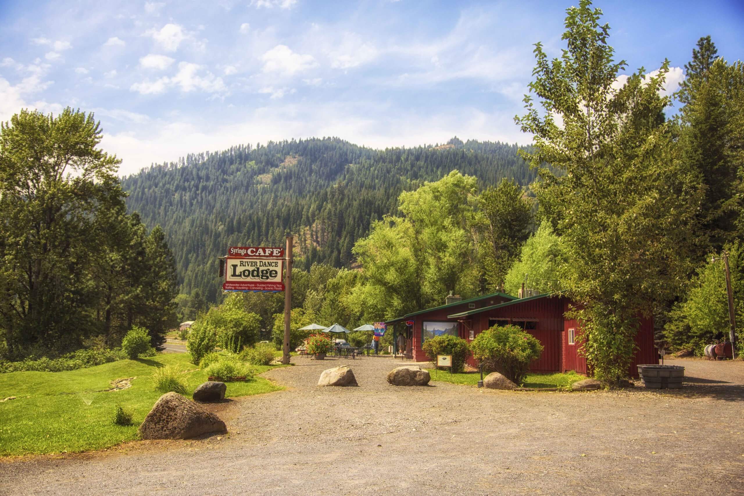 A red building surrounded by green trees and grass.