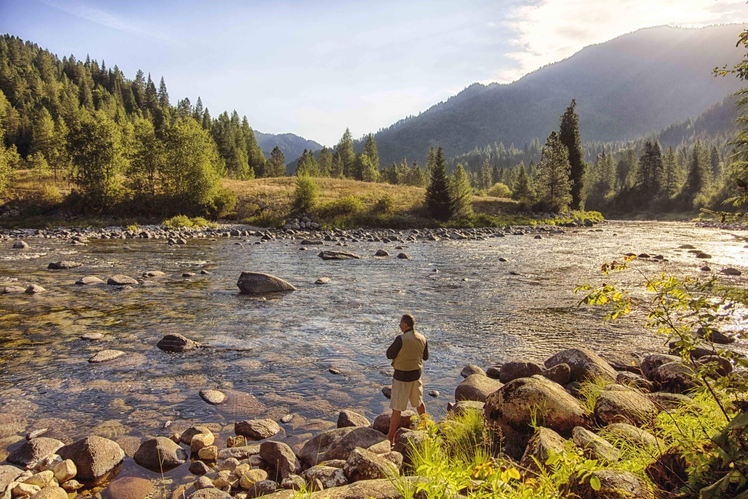 A man fishing in a river.