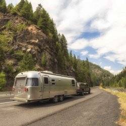 Airstream on the road home with mountain views.