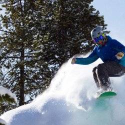 A person completing a jump on a snowboarding run at Lost Trail Ski Area.