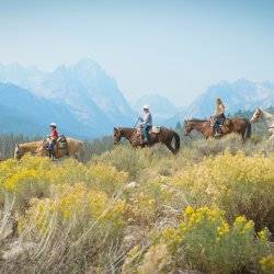 Horseback riders with Sawtooth Mountains in the background.