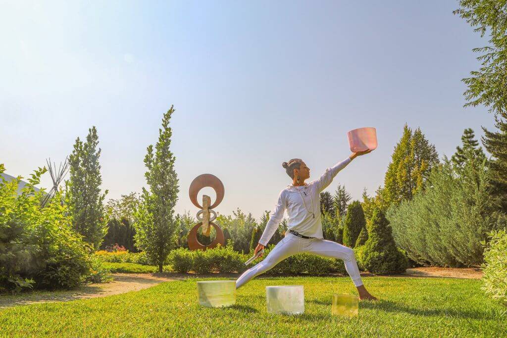 man doing yoga pose in botanical garden