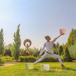 man doing yoga pose in botanical garden