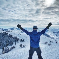 A snowboarder raises his hands and poses at the start of a run at Bald Mountain in Sun Valley.