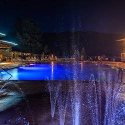 Water fountains glow with nighttime lights at the Springs.