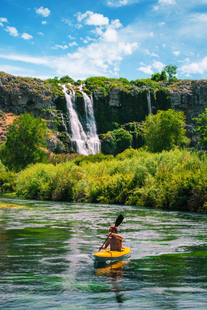 Kayaking underneath a waterfall.