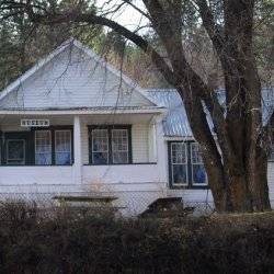 White clapboard sided home with Museum sign hanging over porch.