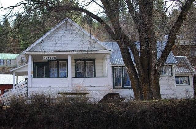 White clapboard sided home with Museum sign hanging over porch.