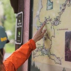 Woman pointing to a location on a trail map.