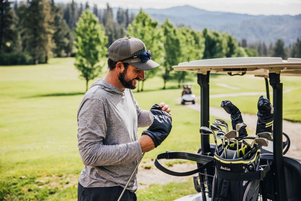 A golfer smiles and takes the cover off a golf club at Terrace Lakes Resort.