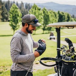 A golfer smiles and takes the cover off a golf club at Terrace Lakes Resort.