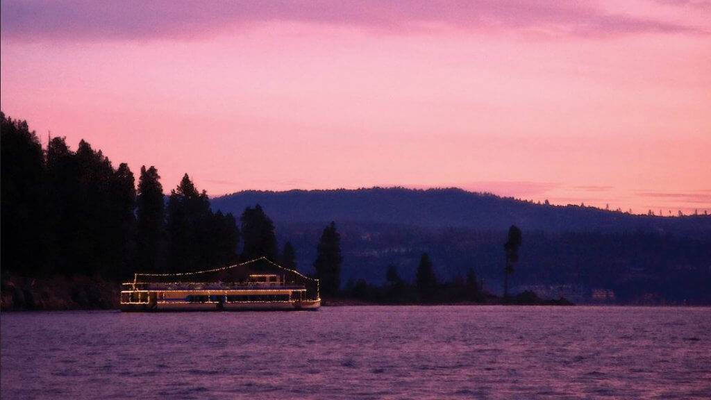 A ferry on a lake at sunset.