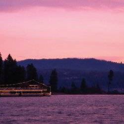 A ferry on a lake at sunset.