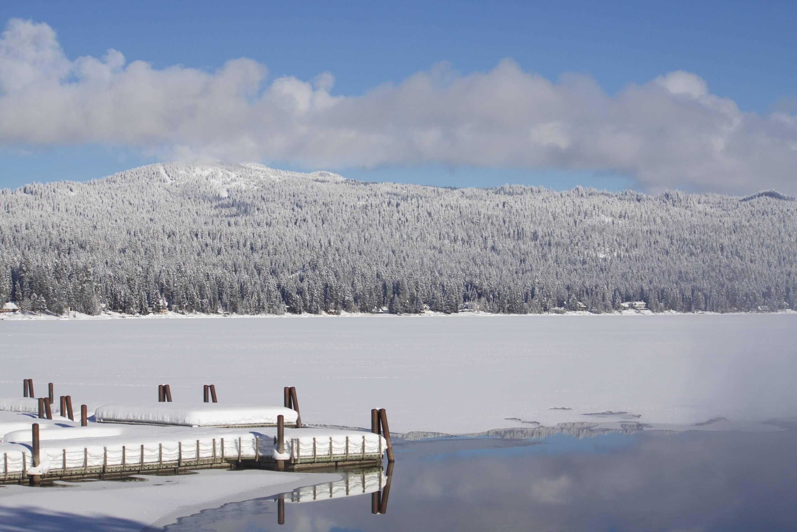 A view of a frozen lake with mountains in the background.