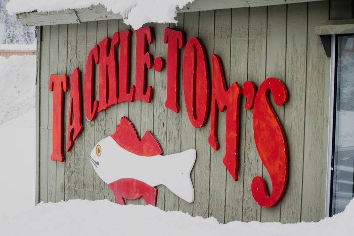 The exterior store sign of Tackle Tom’s: Fishing and Outdoor Equipment store.