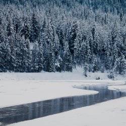 A river in the winter covered in snow.