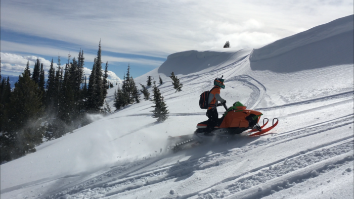 A snowmobiler exploring backcountry.