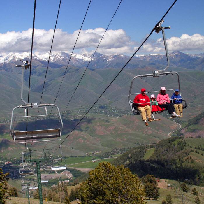 A chairlift going up a mountain in the summer.