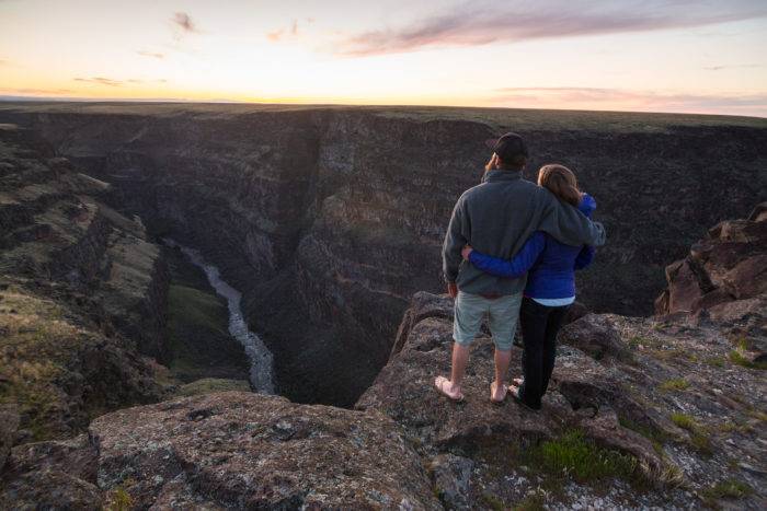  A couple looks into the Bruneau Canyon at sunset.