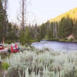 Camp chairs set up riverside to enjoy the early evening view.