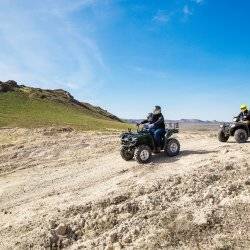 A family riding ATVs on a trail.