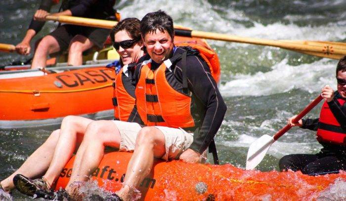 A family enjoying a ride down a river on a raft.